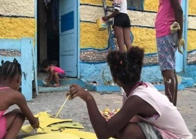 Photo of guys from Arte d'Zona in action, decorating a wall into a design of Cape Verdean flag